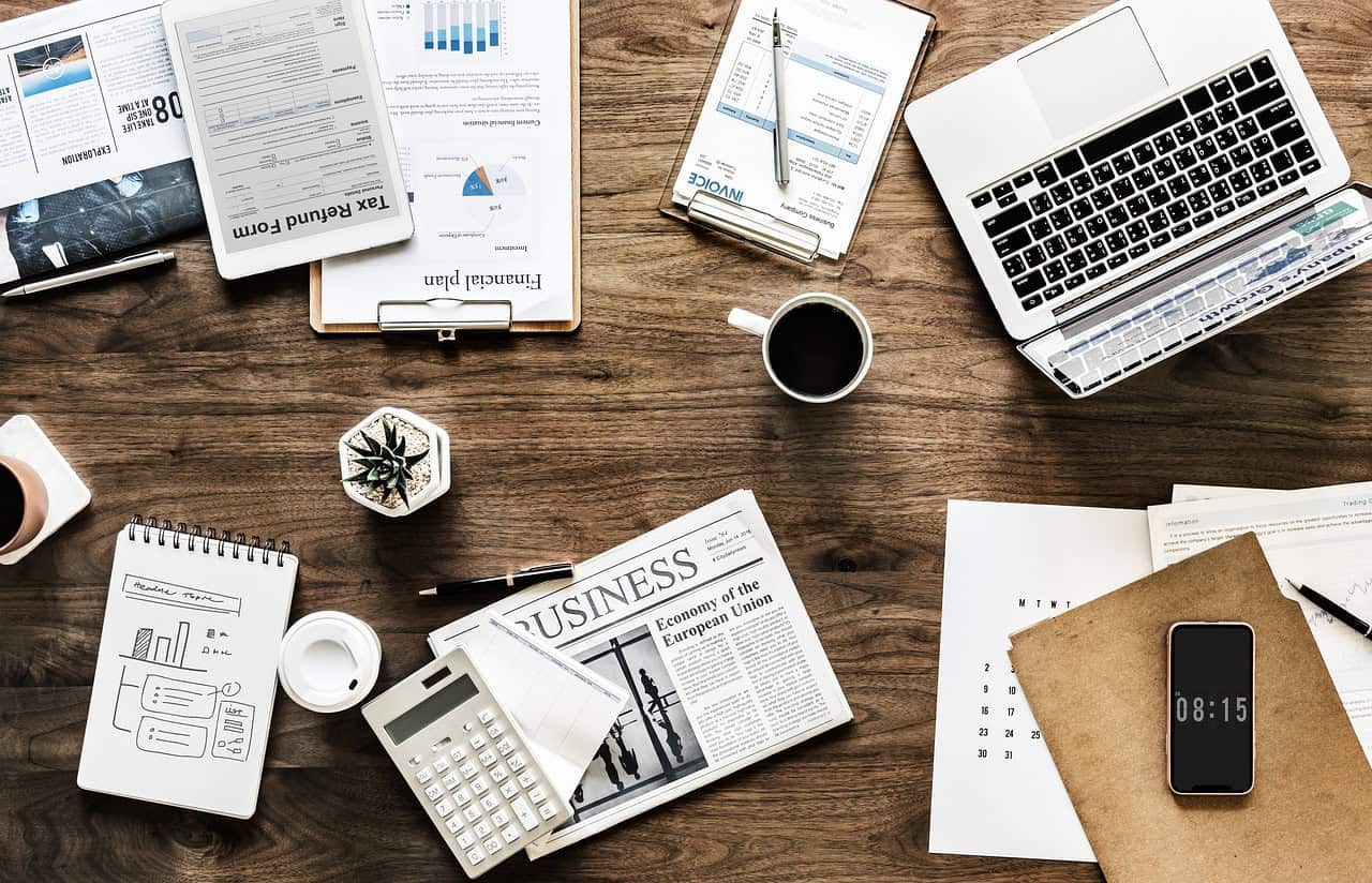 Workspace featuring laptops, charts, and notes for live chat monitoring and customer support.