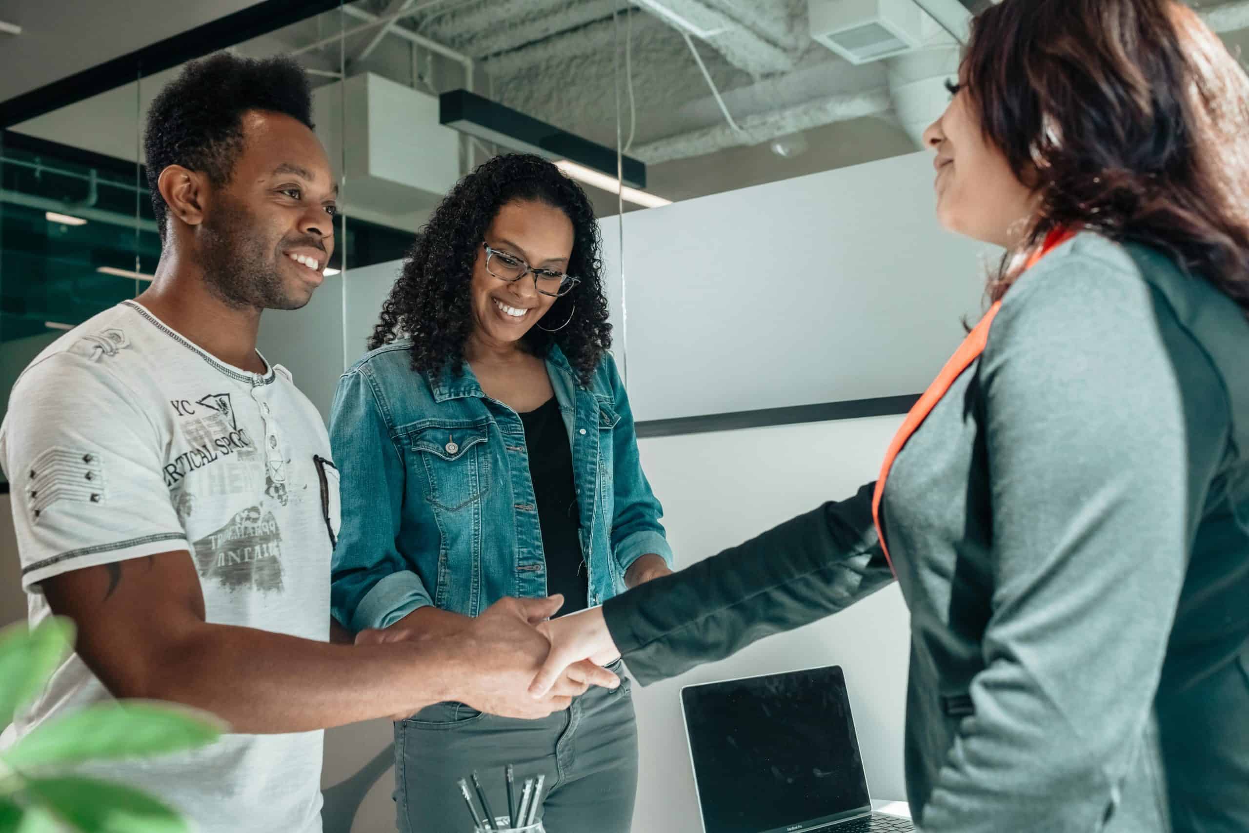 Diverse team shaking hands, discussing customer service and live chat solutions.