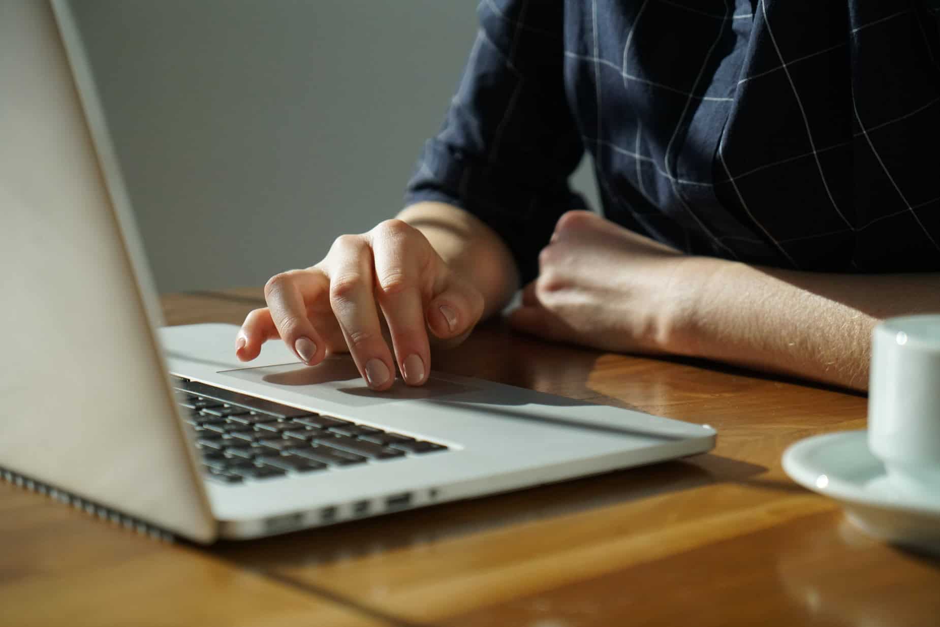Close-up of a person using a laptop for live chat customer support.