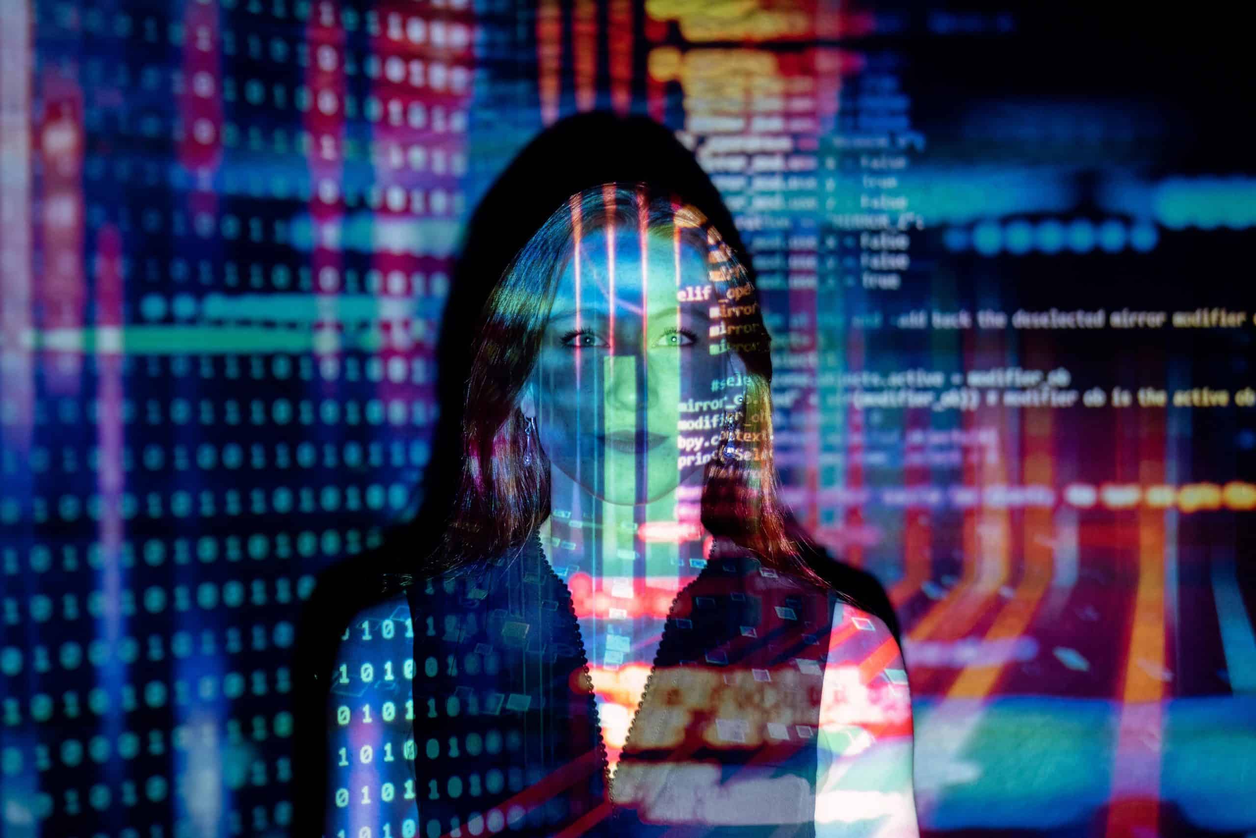 Woman illuminated by projected lines of code, symbolising the blend of human expertise and advanced AI in digital support.