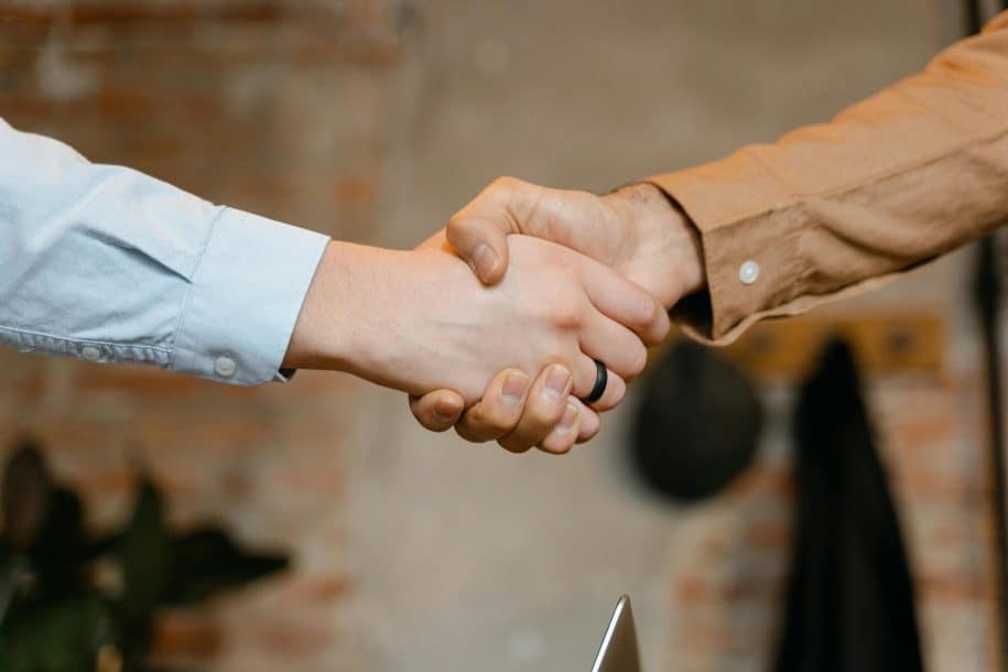 Close-up of two people shaking hands to symbolize successful live chat monitoring solutions.
