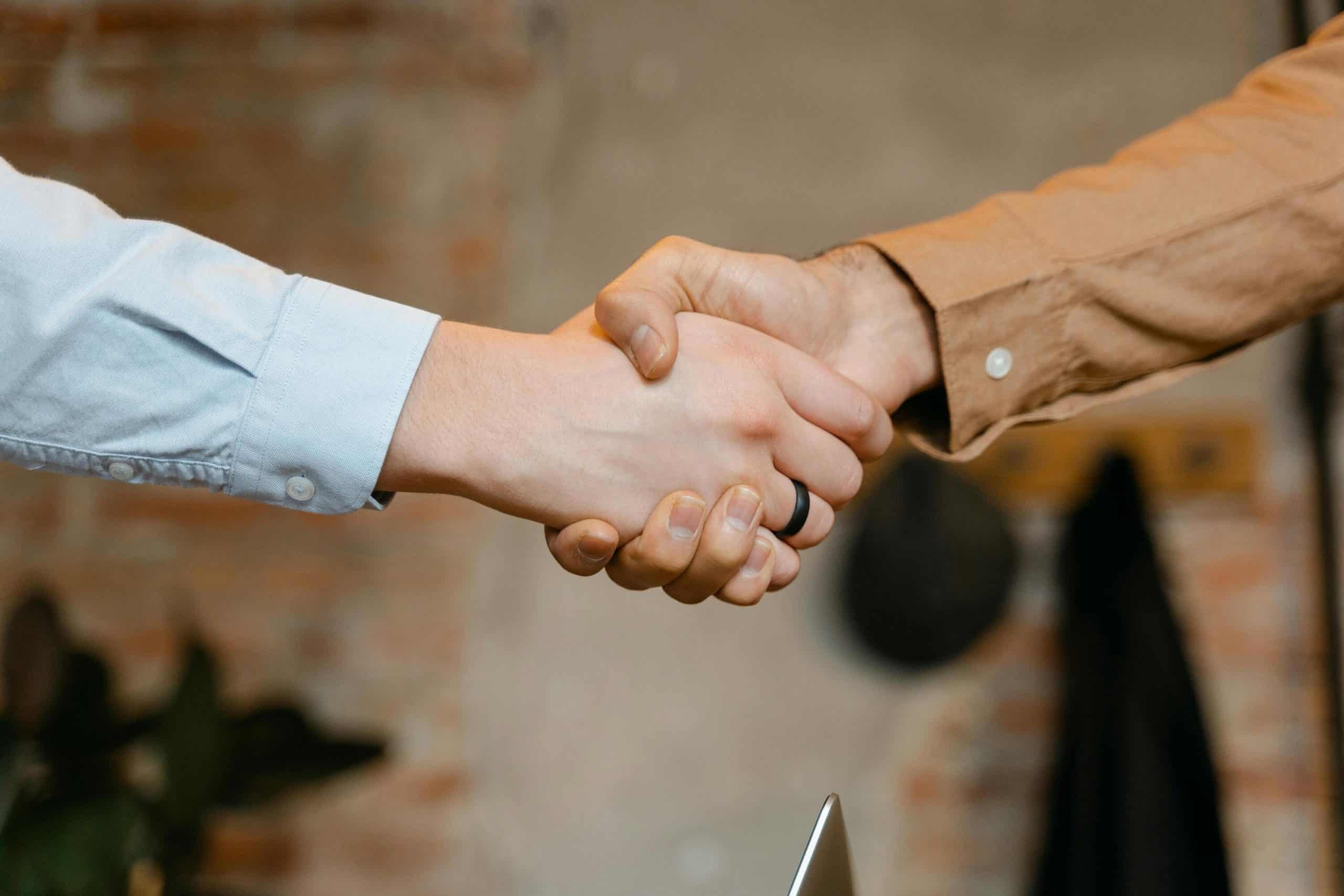 Close-up of two people shaking hands to symbolize successful live chat monitoring solutions.