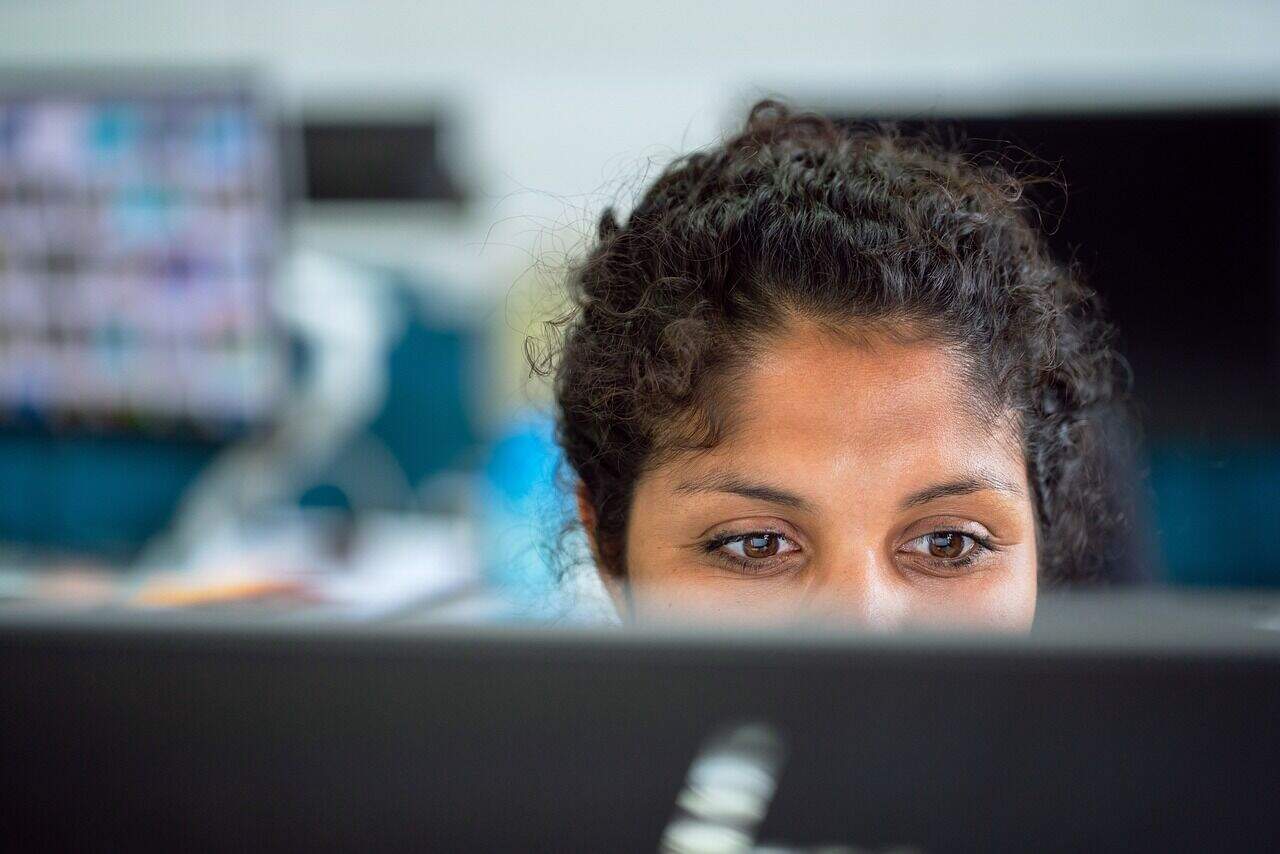 Close-up of a woman monitoring live chat on her computer for customer service.