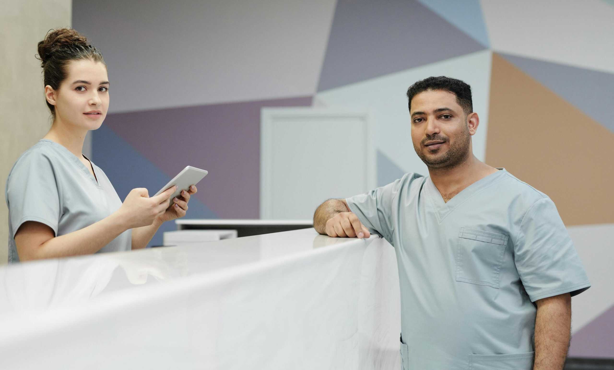 Healthcare professionals using live chat monitoring system at reception desk.