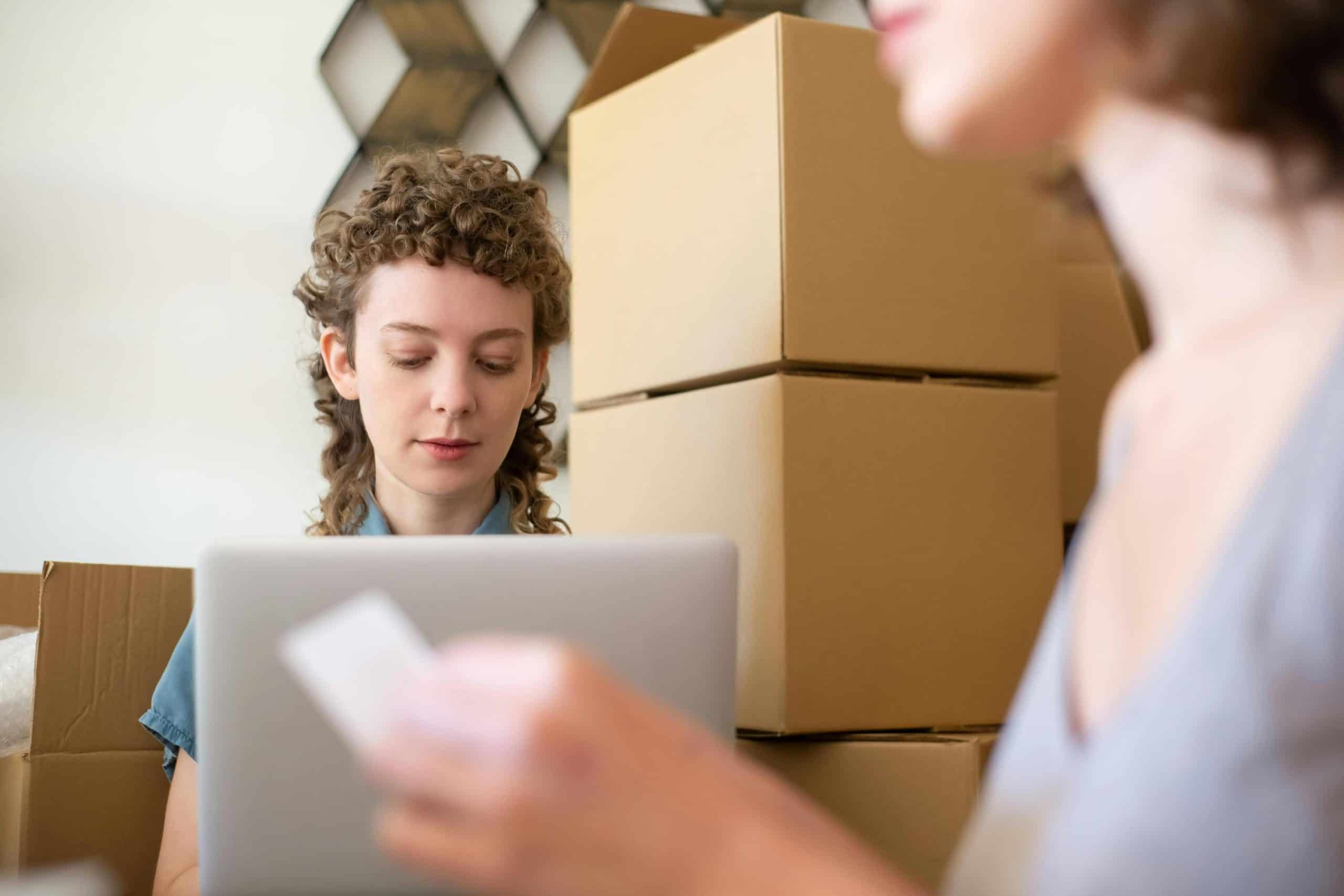Woman using live chat monitoring software in a warehouse setting.