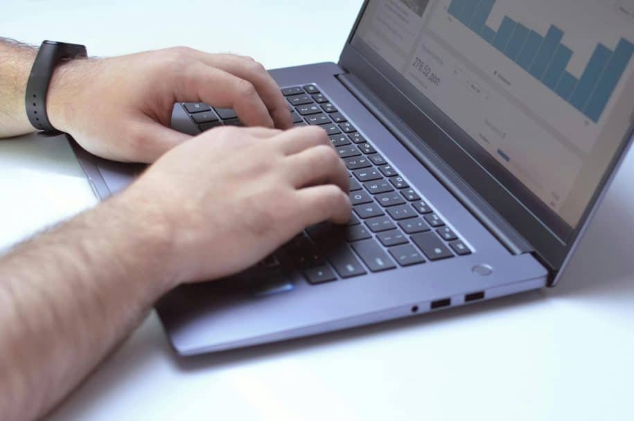 Person monitoring live chat analytics on a laptop screen for customer service insights.